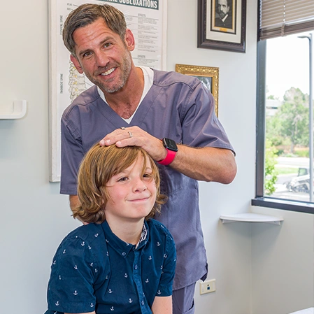 Chiropractor Centennial CO Aaron Johnson With Pediatric Patient